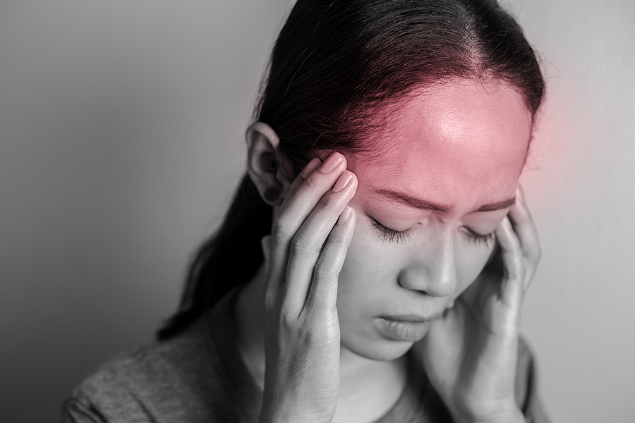 Woman holding head in distress from headache. If you're dealing with chronic migraines and need support coping, working with an online life coach can help. Get in touch to begin coaching for chronic pain in Florida, Texas, Nationwide/ Internationally
