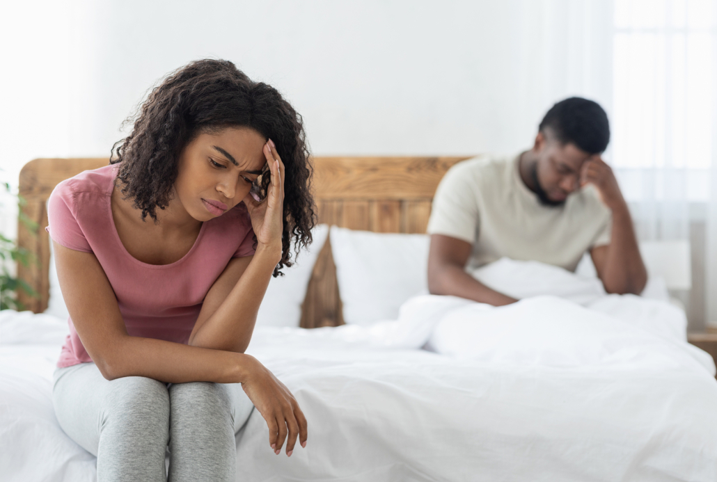 Picture of black couple on bed struggling to connect due to work stress in Florida. If you're struggling, working to develop coping skills for stress in stress therapy may be for you. Get in touch with an online therapist for more guidance today.