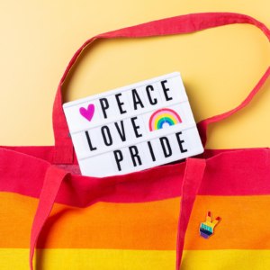 Tote bag with sign saying peace, love, and pride. Talking with an LGBTQ therapist via online therapy can help you establish safety and belonging. Start getting support in LGBTQIA counseling in Brevard County and statewide in Florida. Call now!