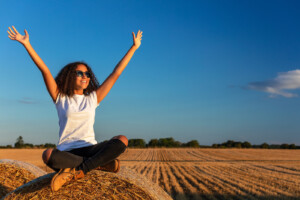 Woman with arms outstretched and smiling. Let's learn about coaching for women. Do you know if you need therapy vs. life coaching? Learn more and see what is the best fit. 