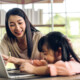 mom and daughter looking at laptop. It may be time to talk with a registered play therapist if communication and connection are offer with your child. Learn more about play therapy in Florida and inquire about play therapy for ADHD today!