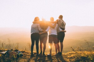 Four young adults with arms around each other near sunset. If you need anxiety treatment, stress therapy, trauma therapy or life coaching, we can help. Learn more about therapy for young adults in Florida and coaching for women. 