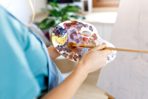 Woman painting. feeling like an overwhelmed mom is exhausting. You are doing all you can. The mom guilt does not need to consume you. Get support from an online therapist in Therapy for new moms in Florida!