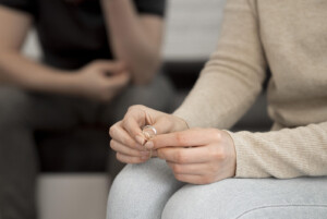 Woman holding wedding band. You never expect to experience infidelity in marriage. If you are working on healing and repairing your relationship marriage counseling and couples therapy can help or try individual counseling soon!