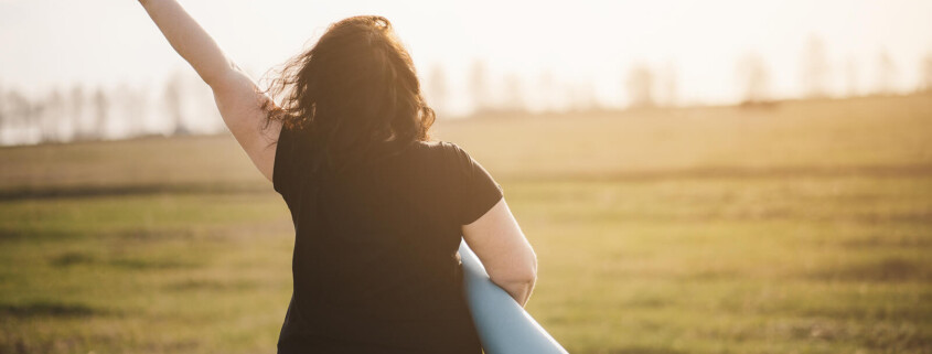 A woman holds up a peace sign while carrying a yoga mat. Learn how an online therapist in Brevard County, FL can help you feel restored and healed. Contact a trauma therapist in Florida to learn more about stress therapy in Florida today.