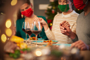 A family wearing masks holds hands around the dinner table. Learn how anxiety treatment in Brevard County, FL can offer support during stressful holidays. Contact an online therapist in Brevard County, FL to learn more about how they can help today. 