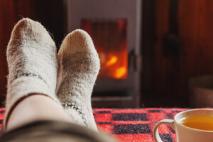 A close-up of feet resting in front of a fire. This could represent the joy felt after working with an online therapist in Brevard County, FL. Learn more about anxiety treatment in Brevard County, FL today. 