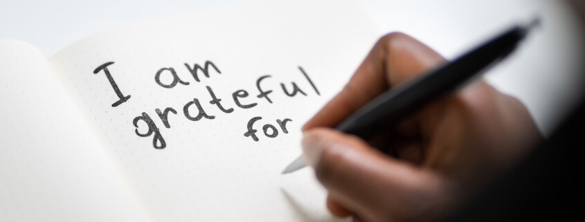 A close-up of a hand writing the words “I am grateful for”. This could represent the gratitude cultivated by working with an online therapist in Brevard County, FL. Learn more about the benefits of gratitude by contacting a family therapist in Brevard County, FL.