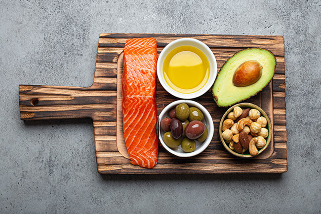 Salmon and healthy sides presented on a wooden serving board.