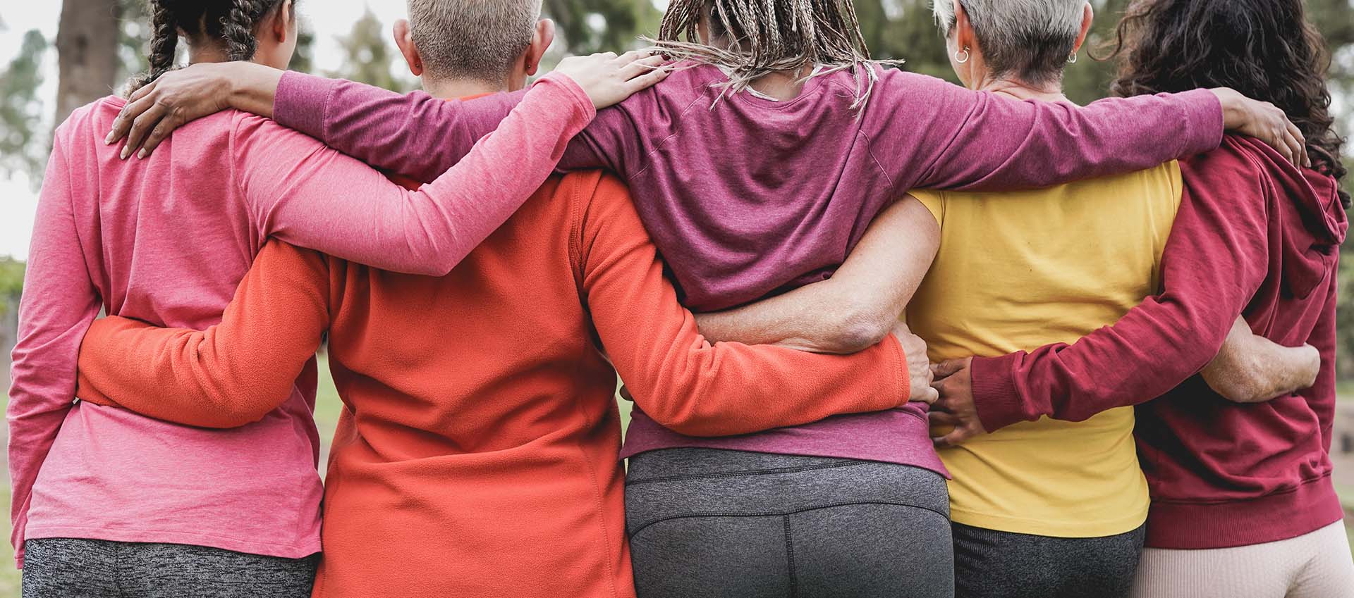 Group of five woman with arms around each other.
