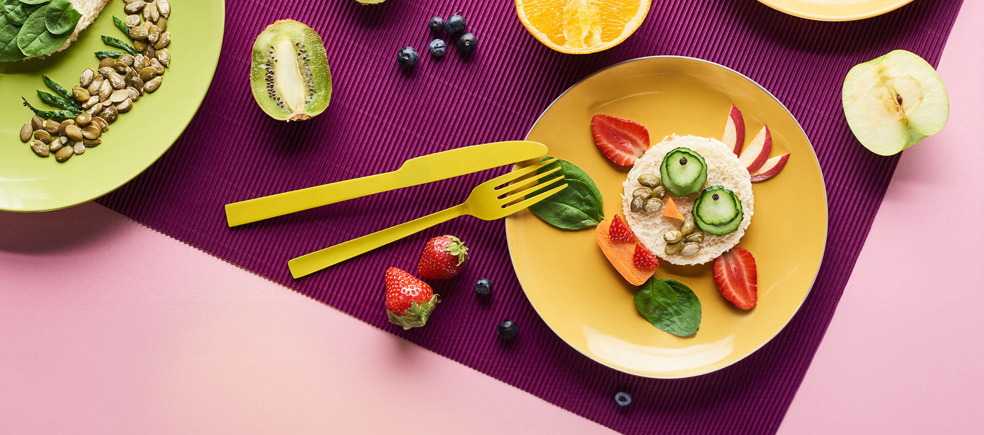 Colorful table setting with amuzing bread and fruit arrangement that looks like a chicken.