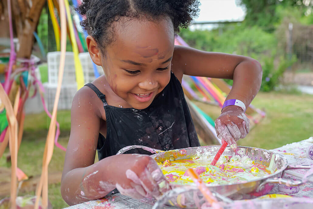 You girl playing with a bowl of multicolor paint . Get support from a child therapist. Call now and begin therapy for children in Brevard County, FL. Our child therapists, and play therapists are ready to support you. Call now!