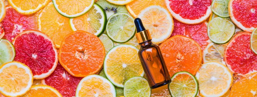 Essential oil bottle against a backdrop of citrus slices