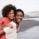 A BIPOC mom with her daughter on a Florida beach