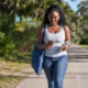 Young woman walking on a paved path while talking on her smart phone depicting virtual walk and talk therapy in Florida