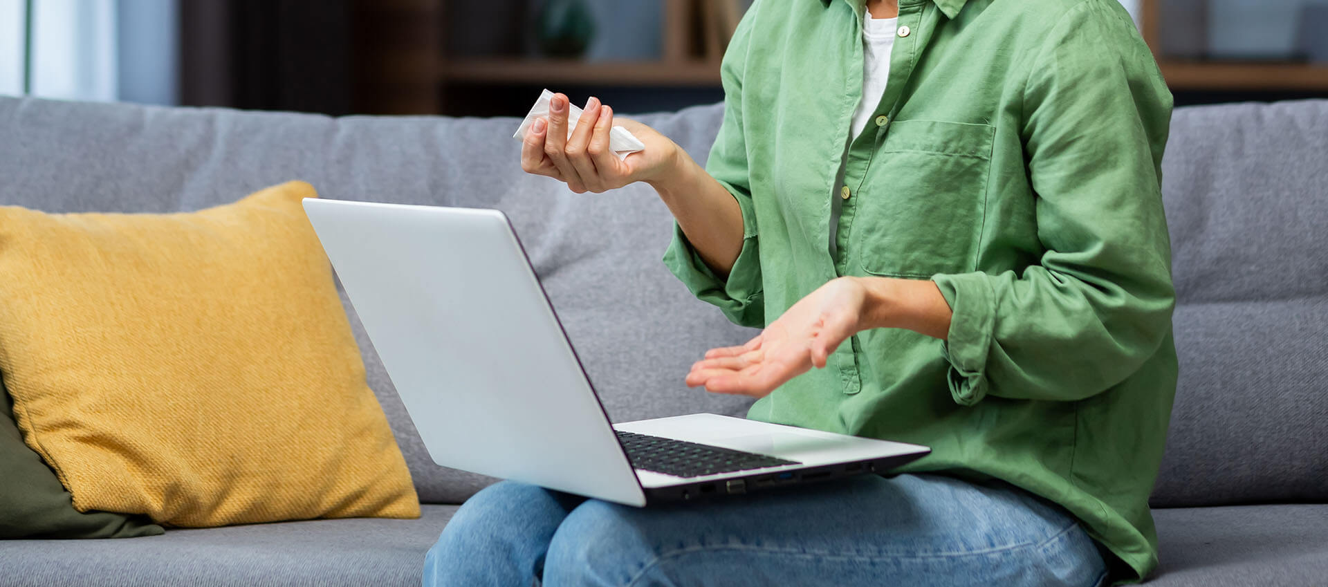 Person sitting on a sofa using a laptop for online anxiety therapy in Florida