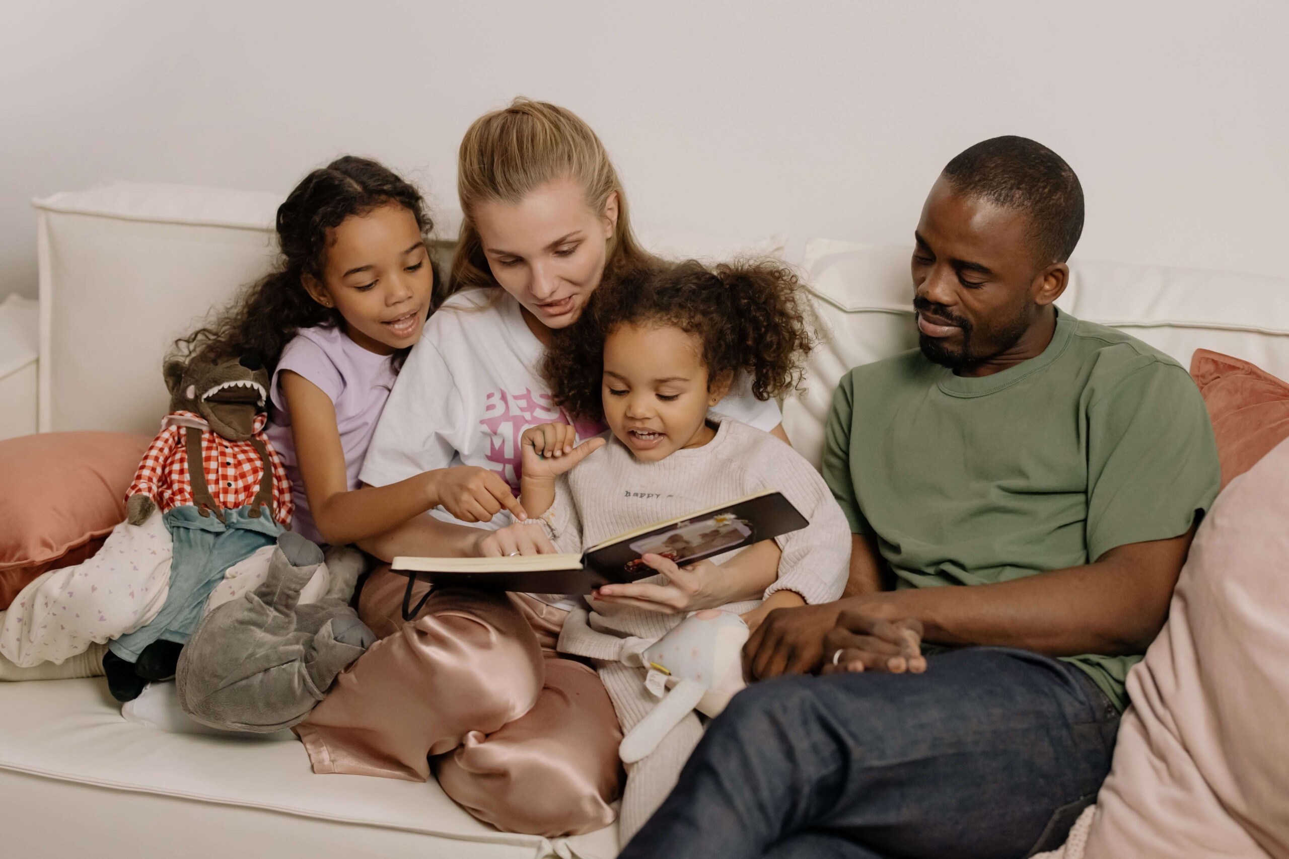 A family sits together on the couch, looking through a book and smiling. Does stress at work often stay hidden until you're home with family? Therapy for anxiety and stress in Florida can help you process what you carry all day.