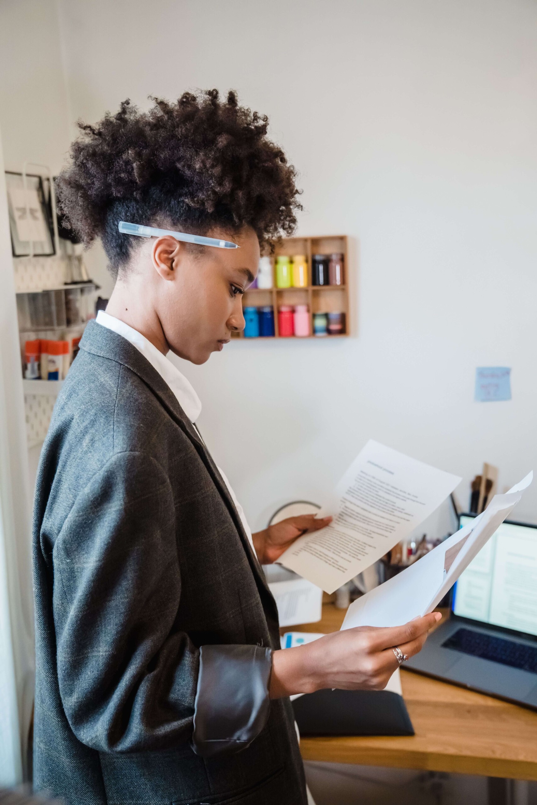 A woman in business attire reviews documents while standing in her home office. Does stress often show up more clearly at home than it does at work? Therapy for anxiety and stress in Florida offers a space to unpack what's really going on.
