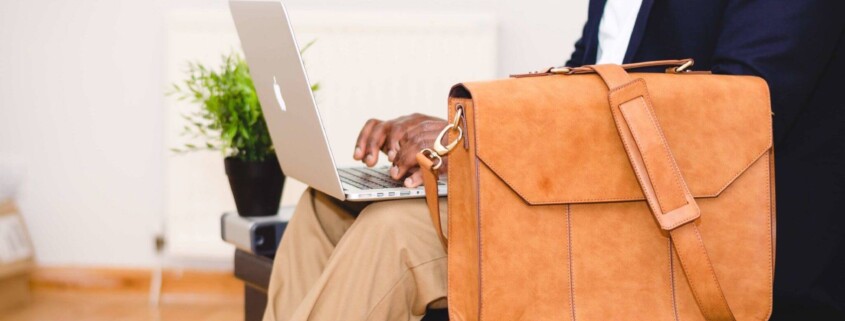 A man in a suit types on his laptop with a leather briefcase resting beside him. Can burnout build quietly behind a calm, put-together appearance at work? A stress and anxiety therapist in Florida can help you recognize the signs before they add up.